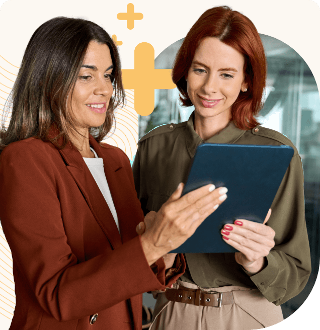 Two female UCaaS MSP professionals discussing a topic looking at a tablet